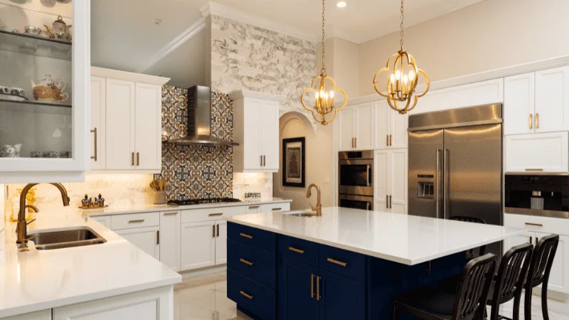 A beautiful white kitchen with two chandeliers