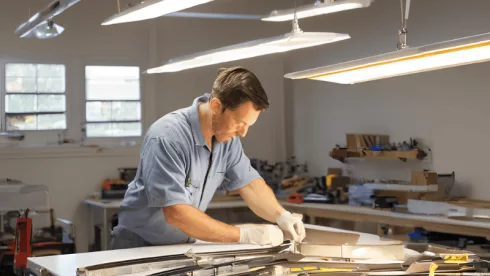 A mechanic replacing Fluorescent Light Fixture with LED Efficiently