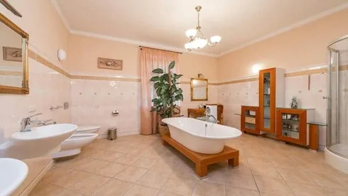 Luxury spacious bathroom in traditional style with ornate metal work chandelier